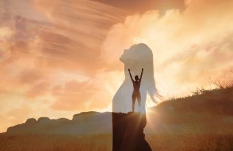 Happy woman on a mountain looking up to the sky. Letting go of a